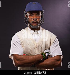 HES vers le haut suivant. Un petit coup de feu d'un jeune homme ethnique en tenue de cricket isolée sur le noir. Banque D'Images