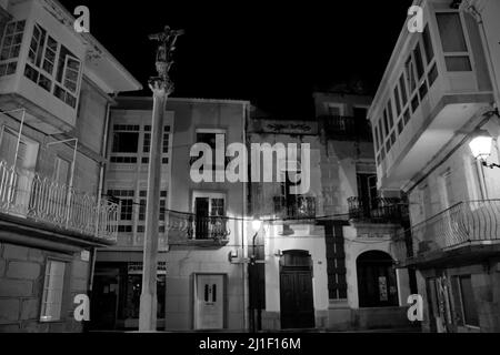 Petite place déserte la nuit avec une croix religieuse dans la petite ville de Muros Banque D'Images