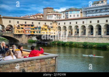 Ponte Vecchio et Vasari Corridor à Florence, restaurant et personnes pratiquant l'aviron Toscane, Italie Banque D'Images