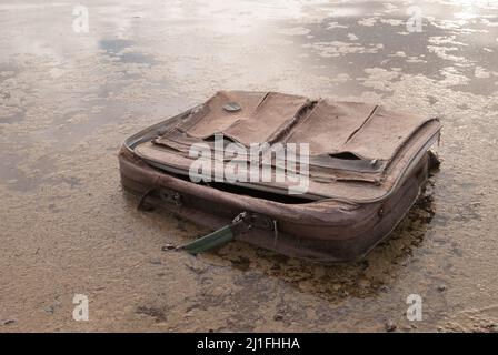 Ancienne valise de voyage American Flyer mise au rebut dans le lac.en corbeille, ancienne valise. Rêve perdu. Pas de plans. Bagages de voyage laissés derrière. Sac American Flyer. Banque D'Images