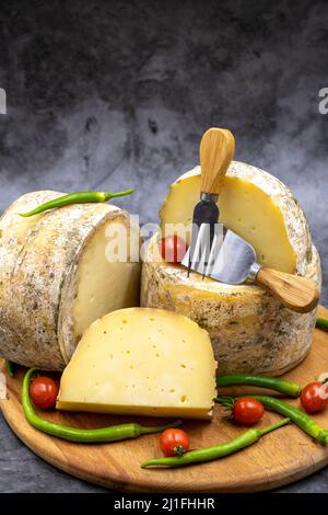 Fromage cheddar de chèvre sur fond sombre. Gros plan Banque D'Images