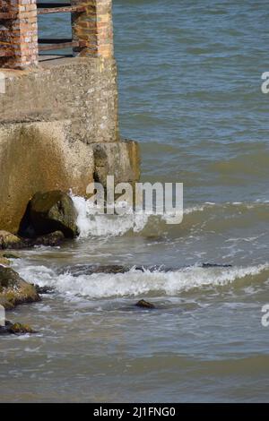 de grandes vagues de mer éclaboussant contre un quai. La jetée coupe les vagues de la mer au large de la côte pendant une journée ensoleillée. Banque D'Images