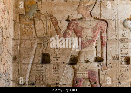 Sculpture murale montrant le dieu Osiris offrant le crook et le fléau au roi Seti I dans le Grand Temple d'Abydos, en Égypte Banque D'Images