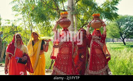 23 mars 2022 Reengus, Rajasthan, Inde. Concept de religion hindoue. Les femmes indiennes traditionnelles tiennent Clay Kalash à la tête d'un festival hindou Banque D'Images