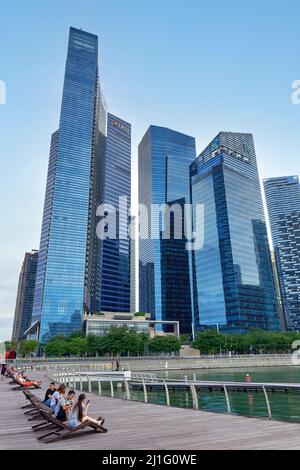 Singapour. Marina Bay. Les gens se détendent dans le quartier financier des affaires Banque D'Images