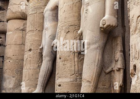 Jambes de statues entre les colonnes de la cour de Ramsès II, Temple de Louxor Banque D'Images