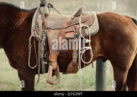 Une image rapprochée d'une selle de l'Ouest sur un cheval de travail sur un ranch ou une ferme à l'atmosphère vintage Banque D'Images