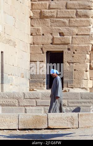 Egyptien local marchant devant le premier pylône du Temple d'Isis à philae Banque D'Images