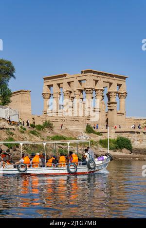 Touristes arrivant par le Nil pour visiter les philaes, avec le kiosque de Trajan en arrière-plan Banque D'Images