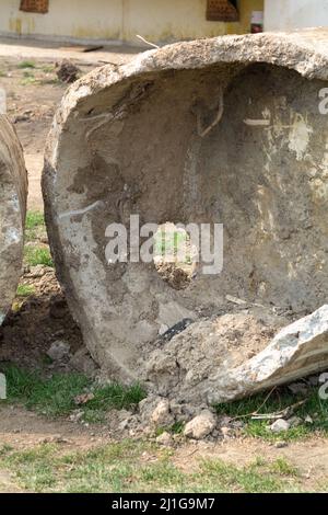 Anneau d'égout. Anneau d'égout cassé recouvert d'argile et de sable sur la pelouse près de l'aire de jeux. Construction ou réparation d'égouts d'appartements résidentiels Banque D'Images