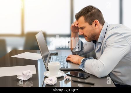 Homme d'affaires submergé et affligé par son travail au bureau. Désespoir et frustration au travail Banque D'Images