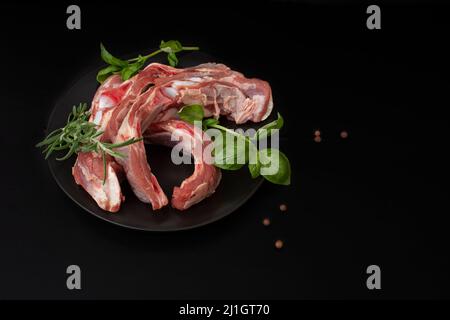 côtelettes de bœuf hachées sur une assiette noire avec des herbes vertes et toutes les épices Banque D'Images