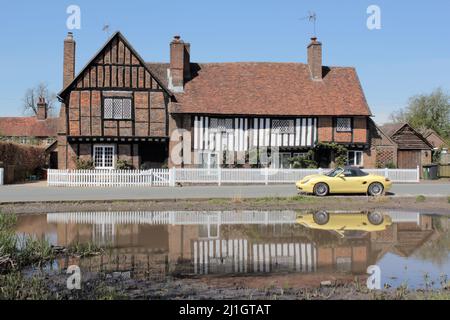 Pond & The Old Manor House avec voiture de sport jaune garée, Aldbury Village à Spring, Hertfordshire, Angleterre, Royaume-Uni Banque D'Images