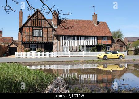 Pond & The Old Manor House avec voiture de sport jaune garée, Aldbury Village à Spring, Hertfordshire, Angleterre, Royaume-Uni Banque D'Images