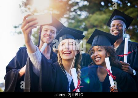 C'est un jour bien ne jamais oublier. Photo rognée d'un groupe d'étudiants de l'université prenant un selfie le jour de la remise des diplômes. Banque D'Images