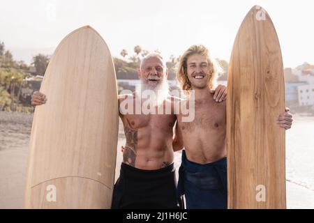 Surfeur multigénérationnel père et fils s'amusant après la session de surf pendant les vacances d'été - Focus sur le visage de l'homme âgé Banque D'Images