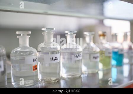 Récipients de produits chimiques sur la tablette dans un environnement stérile du laboratoire. Chimie, laboratoire, produits chimiques Banque D'Images