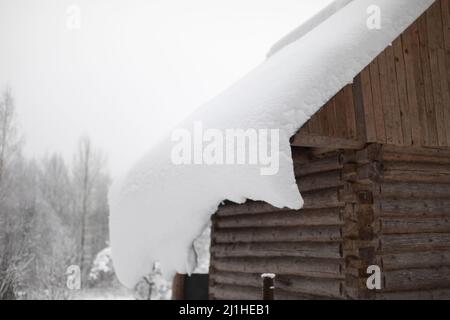 Maison dans village en hiver. Neige sur le toit de la vieille maison. Refuge en Russie. Hiver dans le village. Banque D'Images