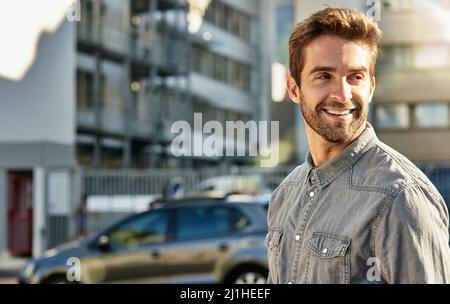 HES, une ville qui s'élance. Photo courte d'un jeune homme charmant qui marche dans la ville. Banque D'Images