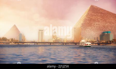 Coucher de soleil sur le Nil avec bateau yacht fond pyramide égyptienne le Caire, Egypte. Banque D'Images