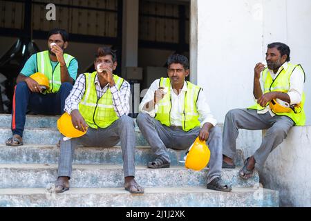 Groupe de travailleurs industriels ayant du thé ou du café pendant la pause - concept de détente, collègues et emplois de cols bleus Banque D'Images