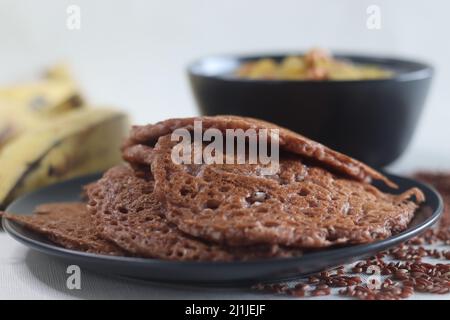 Crêpes de riz rouge. Crêpes faites d'une pâte fermentée de riz rouge et de noix de coco. Servi avec un ragoût de plantain mûr. Une version différente de votre Kerala préféré Banque D'Images