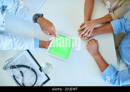 Avec chacun un soutien total, nous pouvons combattre n'importe quoi. Prise de vue en grand angle d'un médecin méconnaissable à l'aide d'une tablette numérique tout en consultant un couple Banque D'Images