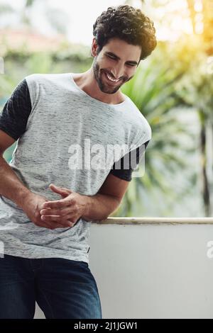 En pensant au splendide jour que j'ai eu, je me fait rire. Photo courte d'un jeune homme beau à la maison. Banque D'Images