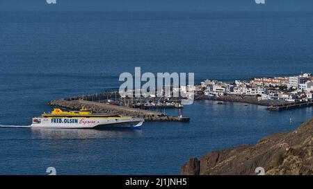 Vue aérienne du village de Puerto de las Nieves sur la côte nord-ouest de Gran Canaria, Espagne avec l'approche de Fred. Ferry Olsen Express par beau temps. Banque D'Images