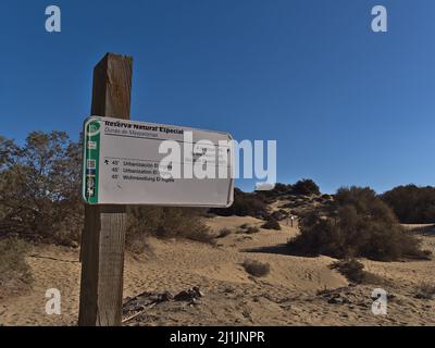 Panneau directionnel dans la zone de protection de la nature Reserva naturel Especial de Dunas de Las Maspalomas à Maspalomas, au sud de Gran Canaria, le jour ensoleillé. Banque D'Images