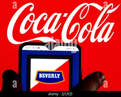 Dans cette illustration, le logo Beverly, Abiter apéritif non alcoolique disponible en Italie est affiché sur un écran de smartphone avec un logo Coca-Cola en arrière-plan Banque D'Images