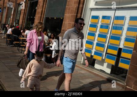 Glasgow, Royaume-Uni. 26th mars 2022. La fenêtre de l'agent immobilier affiche le drapeau ukrainien bleu et jaune au lieu des listes de propriétés de maison, en soutien de l'Ukraine dans leur guerre actuelle avec le président PutinÕs Russie, dans la zone de Merchant City de Glasgow, Royaume-Uni. 26 mars 2022. Crédit photo: Jeremy Sutton-Hibbert/ Alamy Live News. Banque D'Images