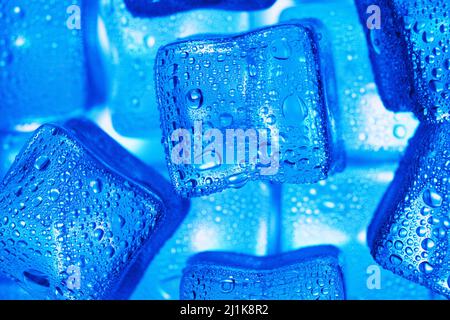 Glace composée de cubes alignés avec des gouttes sur fond bleu Banque D'Images