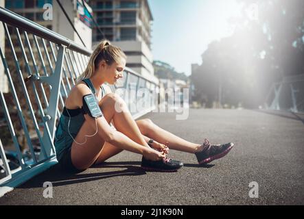 Laçage pour une course. Photo d'une jeune femme sportive nouant ses lacets avant une course. Banque D'Images