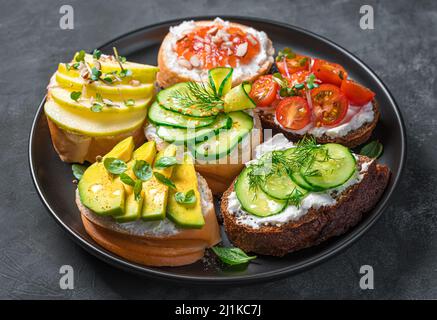 Crostini aux légumes et aux fruits à la ricotta et à la feta. Des collations saines. Assortiment de sandwichs. Banque D'Images