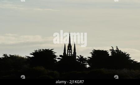 Église de Calvaire en France. Bâtiment religieux avec 3 flèches silhouetées contre la lumière. Vue avant. Banque D'Images