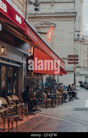 Nice, France - 10 mars 2022: Les gens s'assoient aux tables extérieures de la Brasserie Tobacco Lou Pastrouil dans la vieille ville de Nice, une destination touristique célèbre Banque D'Images