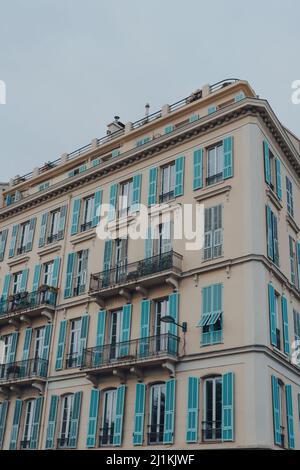 Vue à angle bas d'un immeuble résidentiel traditionnel à Nice, en France, contre le ciel bleu. Banque D'Images