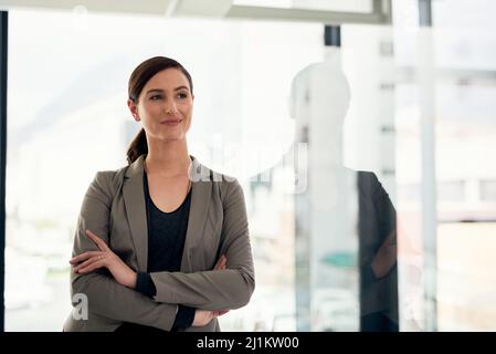 Confiante et déterminée à faire briller son avenir avec éclat. Photo courte d'une jeune femme d'affaires confiante debout dans un bureau. Banque D'Images