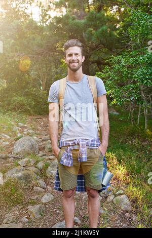 Découvrez la beauté de votre voyage en solo. Photo d'un randonneur heureux debout avec ses mains dans ses poches. Banque D'Images