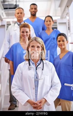Étaient là pour prendre soin de vous. Portrait d'une équipe diversifiée de professionnels de la santé debout sur un escalier dans un hôpital. Banque D'Images