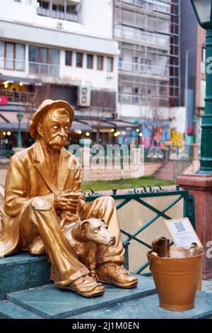 Statue en bronze d'un vieil homme assis avec un chien et un poisson dans un seau au bord de la rivière Banque D'Images