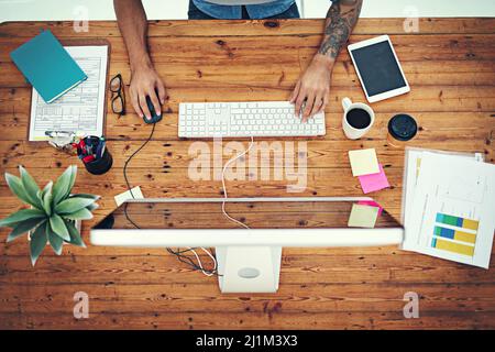 Tous les éléments sont configurés pour une journée de travail productive. Photo en grand angle d'un homme d'affaires utilisant un ordinateur à son bureau dans un bureau moderne. Banque D'Images