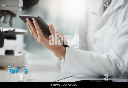 La science fait progresser la technologie et la technologie fait progresser la science. Photo rognée d'une scientifique adulte méconnaissable à l'aide d'une tablette Banque D'Images