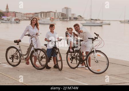 La famille heureuse profite d'une belle matinée au bord de la mer à vélo et à passer du temps ensemble. Le concept d'une famille heureuse Banque D'Images