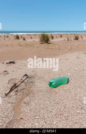 Bouteilles en plastique sur le sable près de la plage et derrière elles vous pouvez voir l'horizon dans la mer. Entretien de la terre Banque D'Images