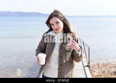 Au printemps, une jeune femme russe boit du café contre la mer japonaise Banque D'Images