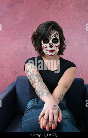Femme tatouée, brunette, face à l'appareil photo et avec le maquillage la Katrina. Banque D'Images