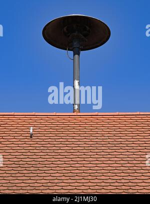 23 mars 2022, Hessen, Niederdorfelden : une sirène est montée sur le toit de la maison Jakob Burkhardt, au centre de Niederdorfelden. Hesse se prépare à la journée d'alerte nationale de septembre. En plus du développement ultérieur des applications d'avertissement, l'accent est mis sur la modernisation et la construction de nouveaux sirènes, ainsi que sur l'introduction d'un nouveau système d'alarme de contrôle des catastrophes par le biais de communications mobiles utilisant des SMS dans l'État. Il y a actuellement environ 4500 sirènes à Hesse. (À dpa: 'Préparatifs pour le jour d'avertissement: Modernisation des lieux de Siren') photo: Arne Ded Banque D'Images