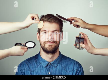 Les vrais hommes se transforment. Studio portrait d'un jeune homme qui se fait un relooking sur fond gris. Banque D'Images